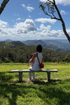 Campingfootprint Suki sitting on the bench in a beautiful campsite
