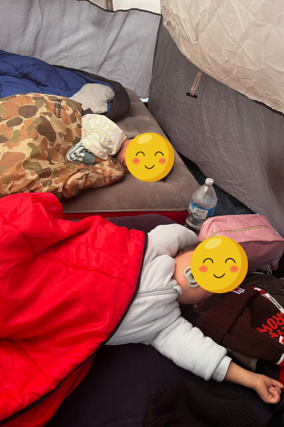 child sleeping comfortably in a kids sleeping bag inside a family tent