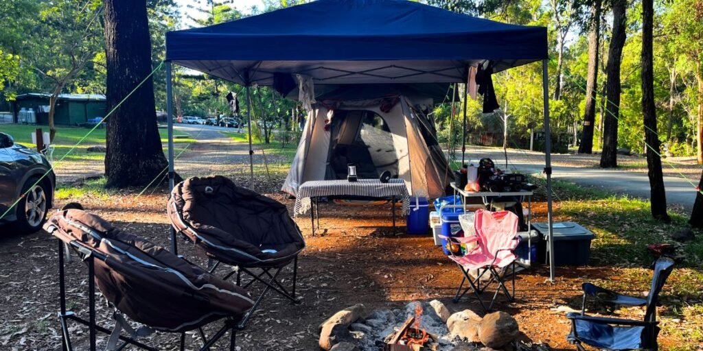 Cosy DIY glamping tent interior with fairy lights, doona, floor rug and lantern at a Queensland campsite