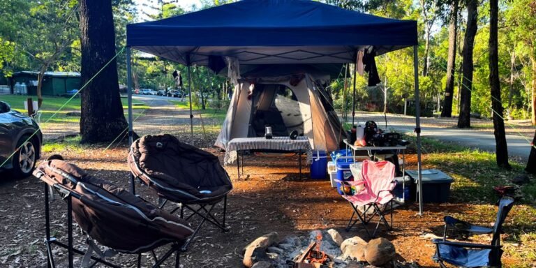 Cosy DIY glamping tent interior with fairy lights, doona, floor rug and lantern at a Queensland campsite